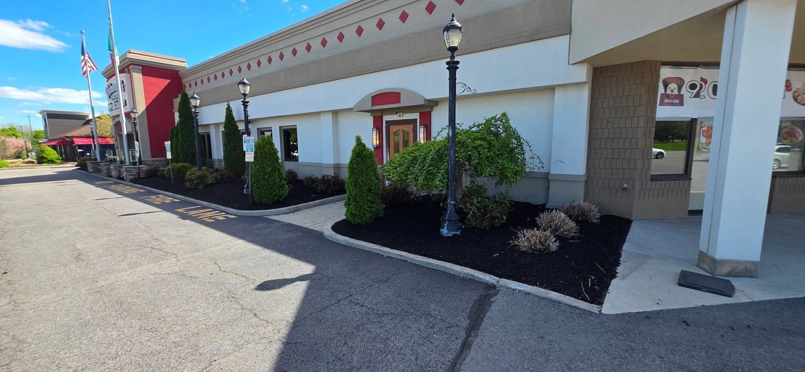 Commercial storefront landscaping with fresh mulch and shaped shrubs